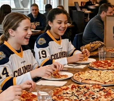 Youth Sports Team Dinners Youth athletes eating pizza together at a team dinner.